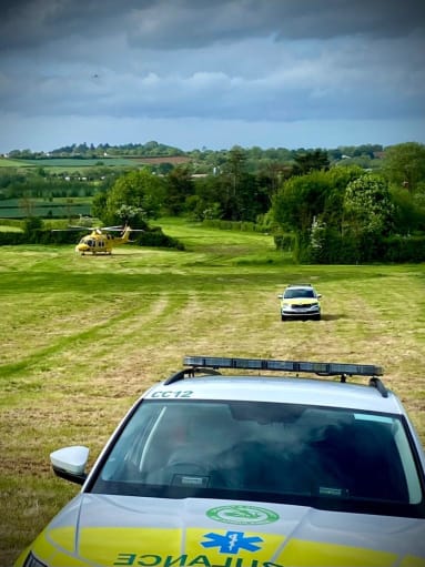 dorset and somerset cars and air ambulance helicopter in field